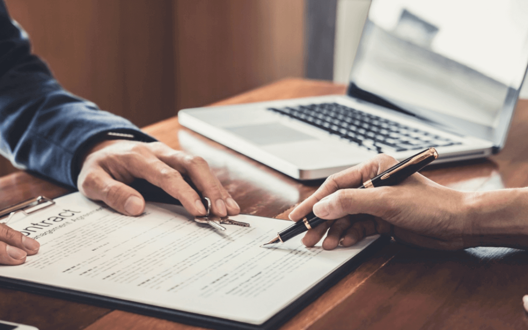 close up of hands signing a contract