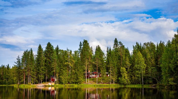 Red wooden cottage by the lake in rural Finland